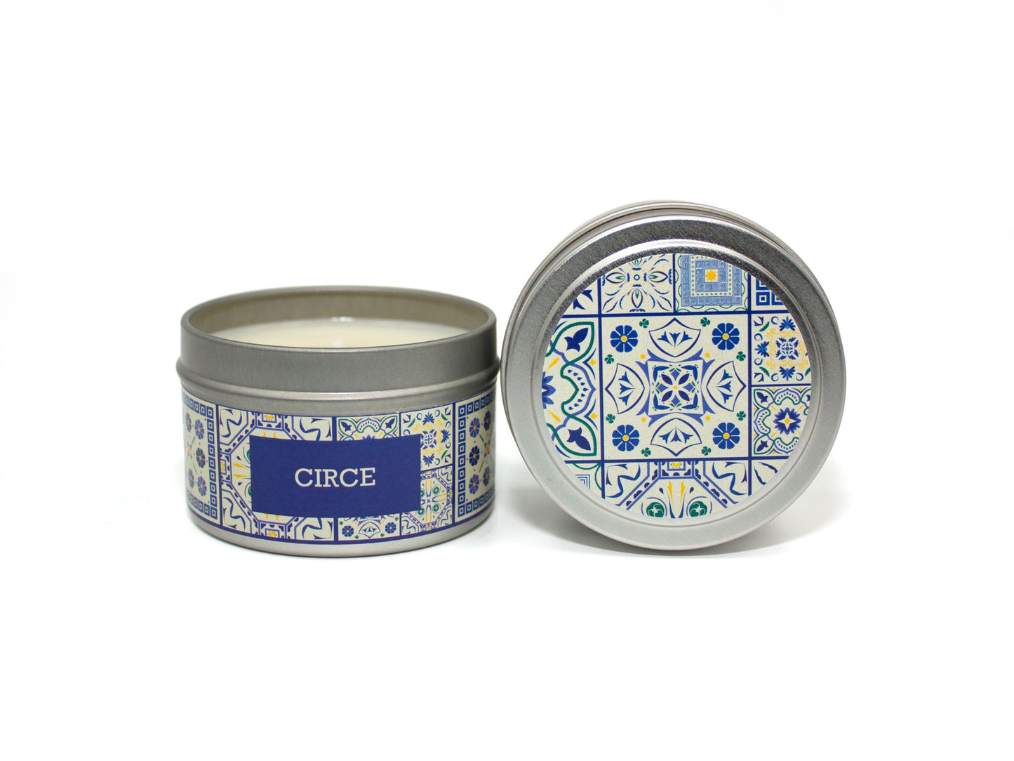 Onset & Rime lemon, cypress scented candle called "Circe" in a 4 oz silver tin. The circular label on top is white with a dark blue Greek tile pattern. The text on the front label is "Circe - Salt Water, Sicilian Lemon, Cypress, Fig".