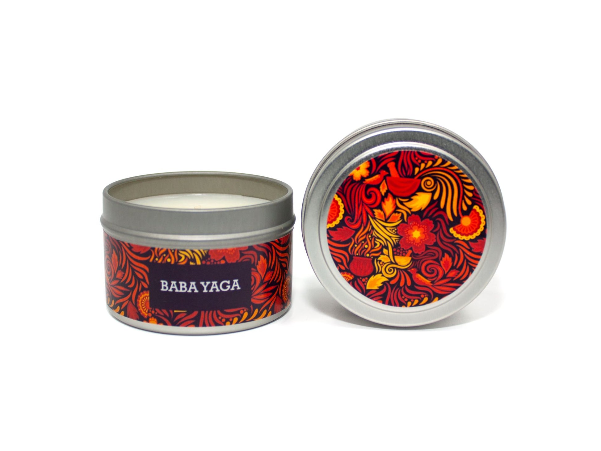 Onset & Rime spiced smoke scented candle called "Baba Yaga" in a 4 oz silver tin. The circular label on top is purple-black with a bright red pattern of flames, swirls and flowers. The text on the front label is "Baba Yaga - Myrrh, Warm Spices, Smoke".