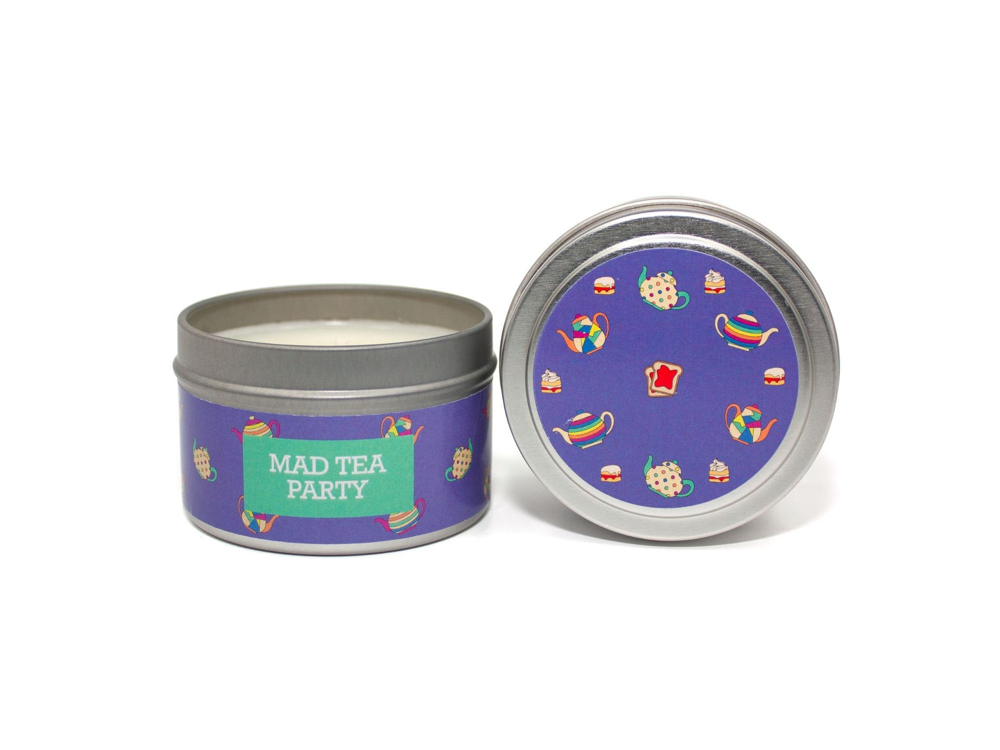 Onset & Rime earl grey tea scented candle called "Mad Tea Party" in a 4 oz silver tin. The circular label on top is purple with a pattern of teacups, cakes and toast with strawberry jam. The text on the front label is "Mad Tea Party - Earl Grey Tea, Strawberry Jam".