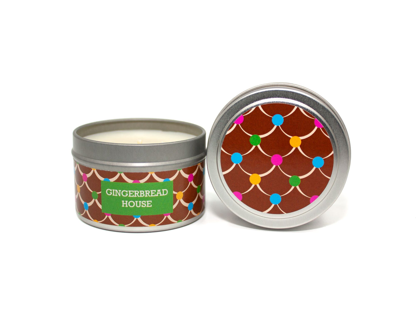 Onset & Rime gingerbread scented candle called "Gingerbread House" in a 4 oz silver tin. The circular label on top is brown with a white icing roof pattern and colourful gumdrops. The text on the front label is "Gingerbread House - Gingerbread, Brown Sugar, Vanilla Icing".