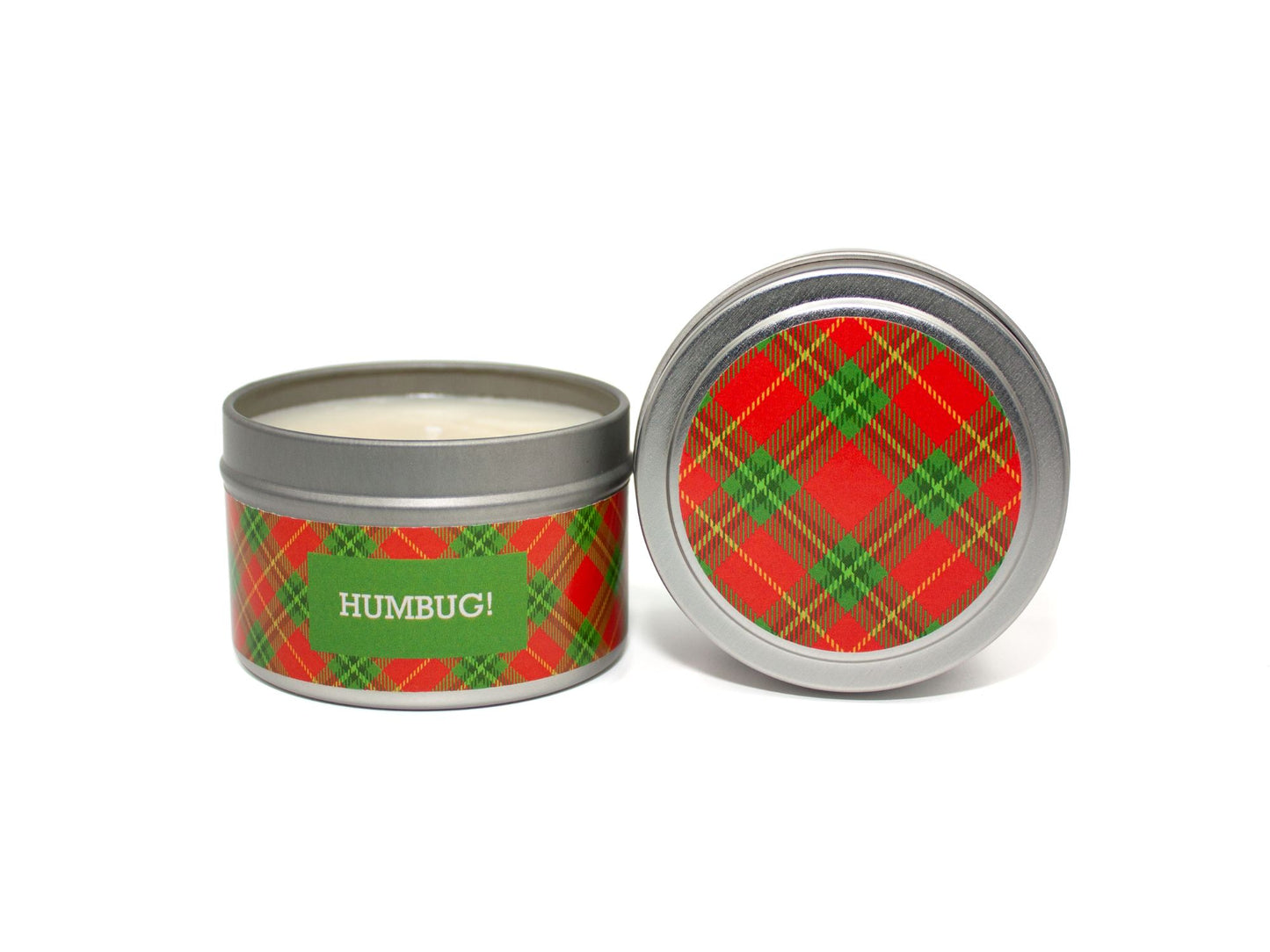 Onset & Rime sweet, smoky scented candle called "Humbug!" in a 4 oz silver tin. The circular label on top is a red and green plaid pattern. The text on the front label is "Humbug! - Roasted Chestnuts, Toasted Marshmallow, Wood Fire".
