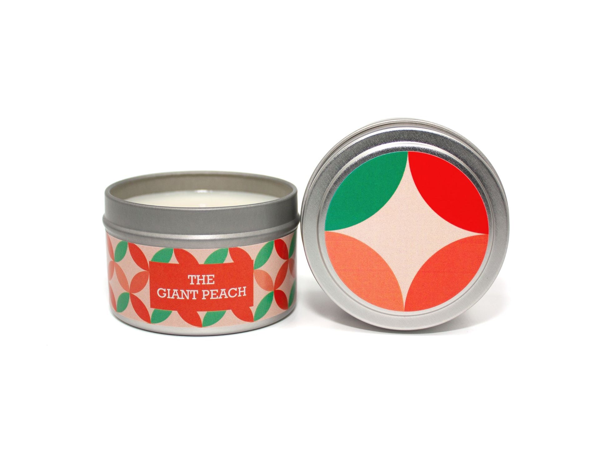 Onset & Rime fresh peach scented candle called "The Giant Peach" in a 4 oz silver tin. The circular label on top has a light peach background with a darker peach and green circular pattern. The text on the front label is "The Giant Peach - Fresh Peach, Lime Zest".