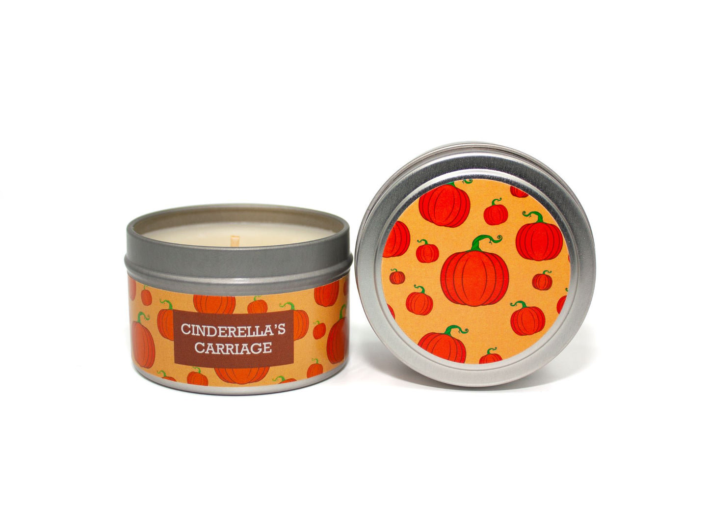 Onset & Rime pumpkin pie scented candle called "Cinderella's Carriage" in a 4 oz silver tin. The circular label on top is light orange featuring a pattern of pumpkins. The text on the front label is "Cinderella's Carriage - Pumpkin, Brown Sugar, Nutmeg, Cinnamon".