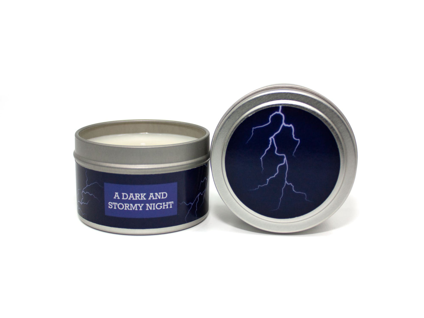 Onset & Rime rain scented candle called "A Dark and Stormy Night" in a 4 oz silver tin. The circular label on top is dark blue with a white lightning bolt. The text on the front label is "A Dark and Stormy Night - Cool Rain, Wet Stone, Oak".