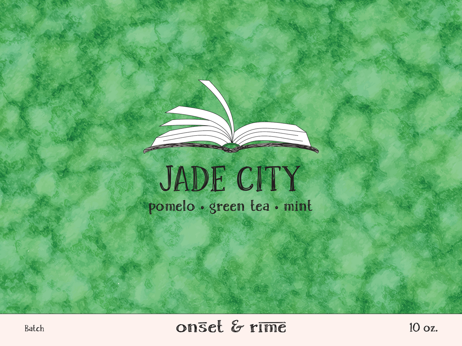 A close up view of the label for the Onset & Rime pomelo, green tea and mint scented candle called "Jade City". The label is cool green with a lighter green mottling. The text on the label is "Jade City - Pomelo, Green Tea, Mint".
