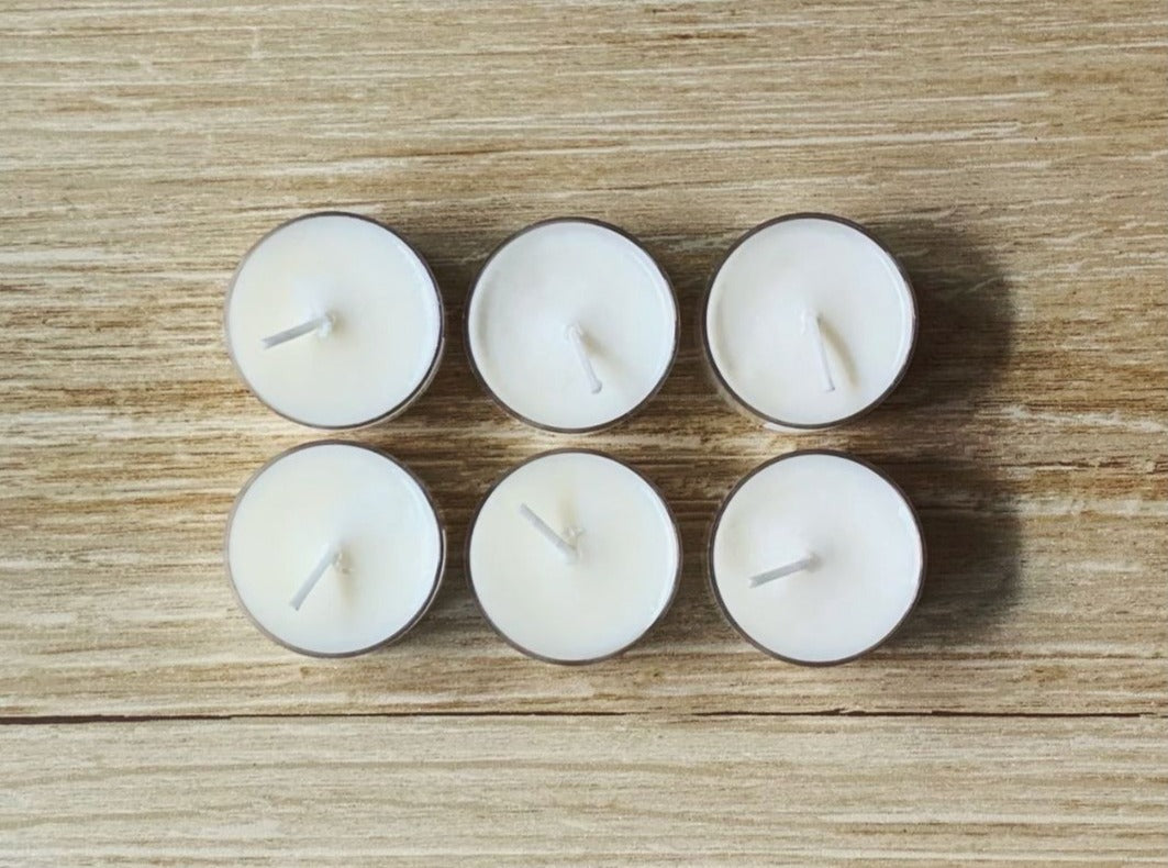 6 tea lights on a wood table.